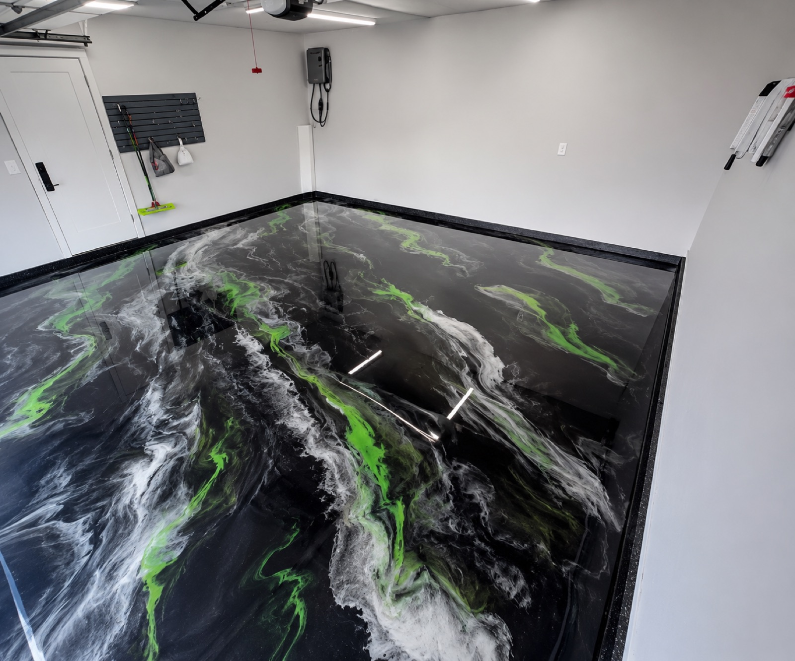 Metallic epoxy floor with marbled black, white, and green finish in a North Dakota garage
